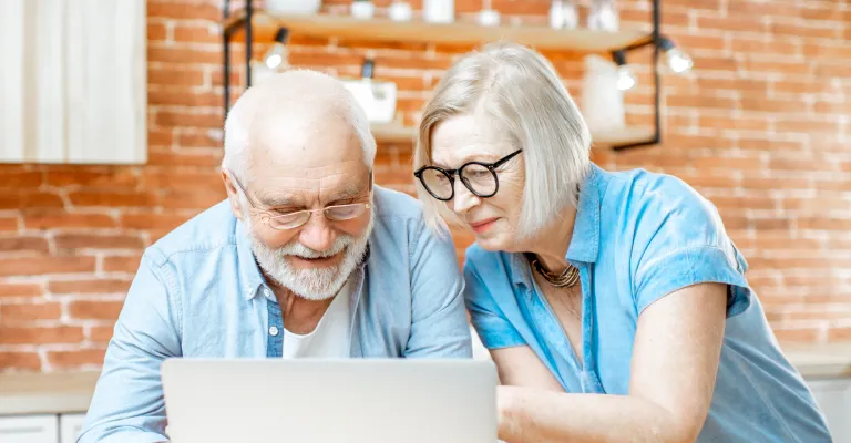Couple interacting with laptop at their couch